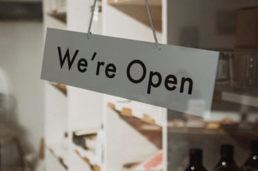 A sign hanging from the side of a glass door
